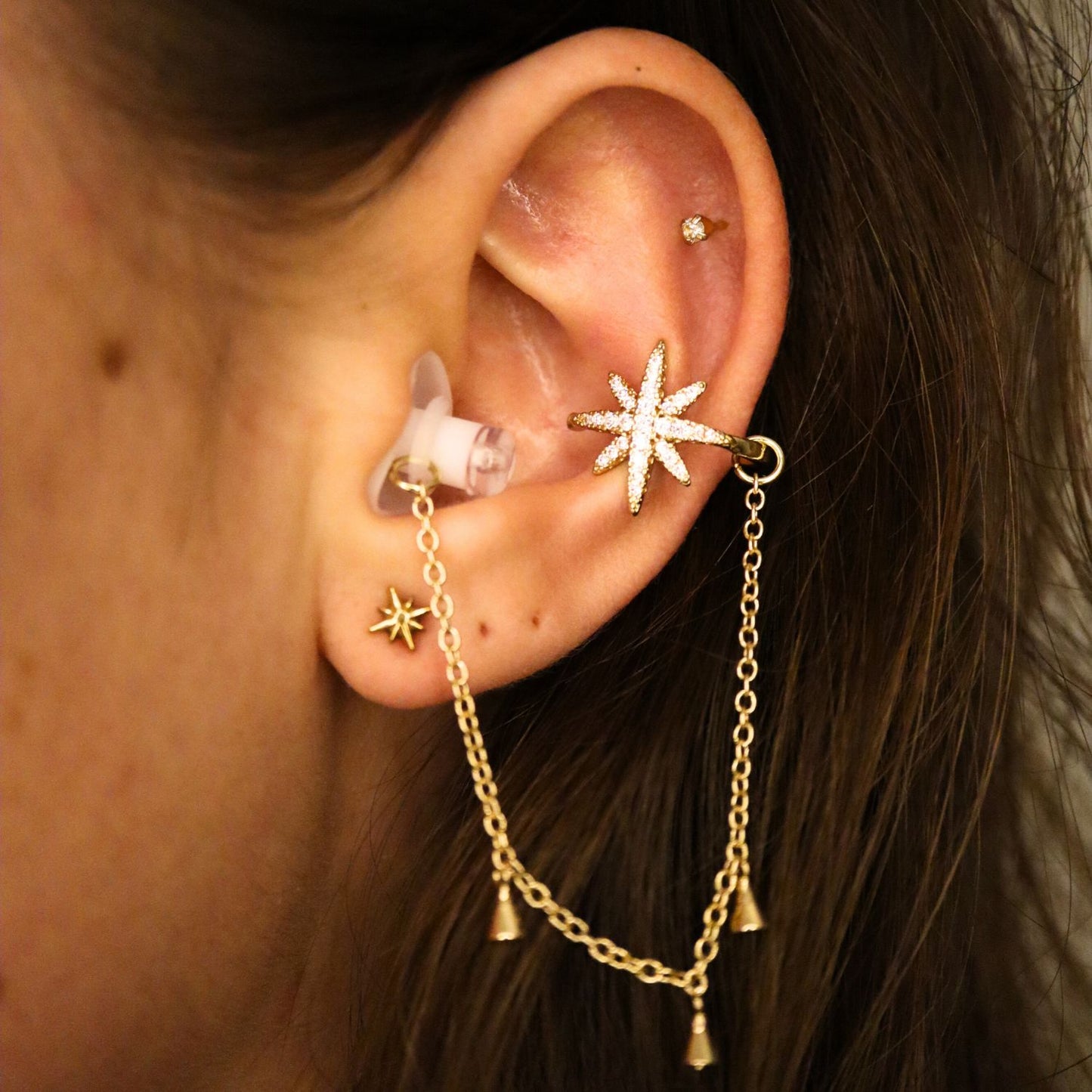 Earcuffs Voor Oordopjes (Ster Kwastjes) Goudkleurig op model met oordopjes